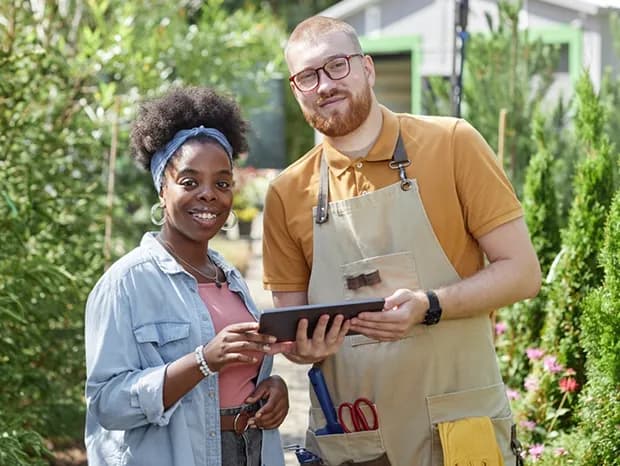 Garden consultants reviewing landscape plans on a tablet outdoors
