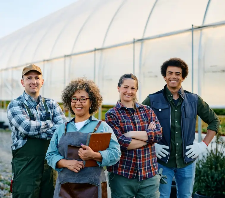 Mahraj Landscaping team standing together in front of a greenhouse